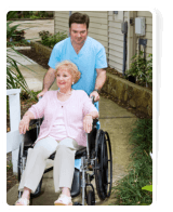 caregiver pushing the wheelchair of the senior woman