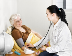 caregiver checking the blood pressure of the senior woman